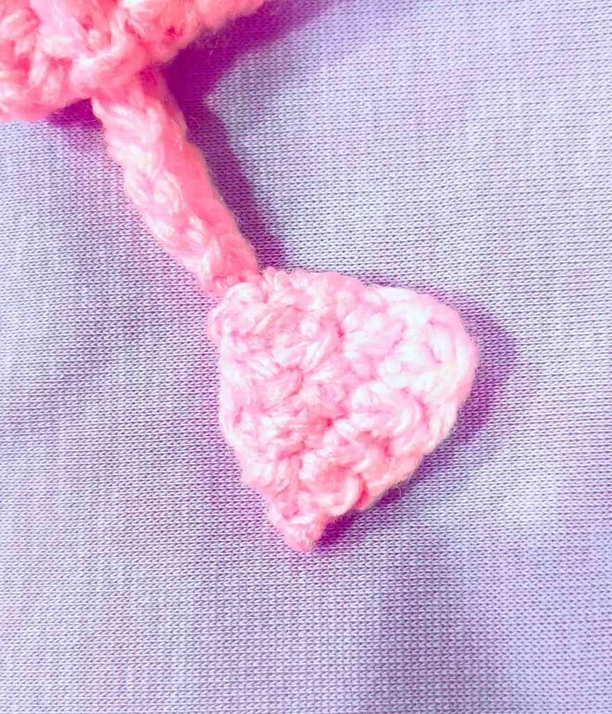 crochet-drawstring A pink drawstring made with crochet is the drawstring for a bag. With a blue background.