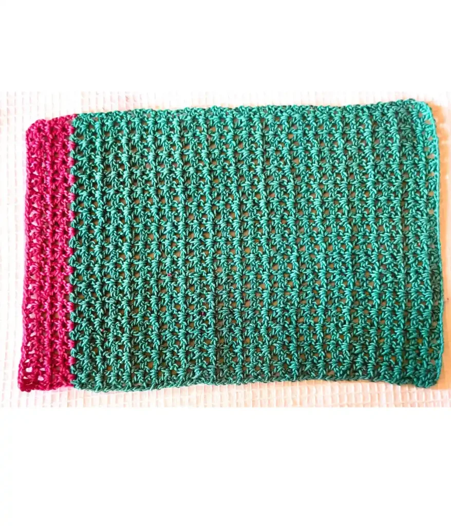 A green and bright pink crochet placemat made by v stitch
